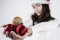 Girl with a christmas hat holding christmas balls in her hands on a white background. christmas concept Royalty Free Stock Photo