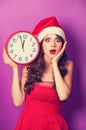 Girl in christmas hat with huge clock Royalty Free Stock Photo