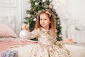 Girl with a Christmas toy in her hands. Portrait of a child with a Christmas ball