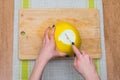 Girl cleans a pomelo on a wooden board Royalty Free Stock Photo