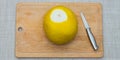 Girl cleans a pomelo on a wooden board Royalty Free Stock Photo