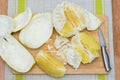 Girl cleans a pomelo on a wooden board Royalty Free Stock Photo