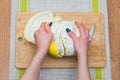 Girl cleans a pomelo on a wooden board Royalty Free Stock Photo