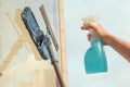 Girl Cleaning open Window of balcony by spraying Cleaning Products and wiping with mop Sponge at the summer sunset evening.