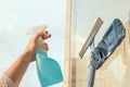 Girl Cleaning open Window of balcony by spraying Cleaning Products and wiping with mop Sponge at the summer sunset evening.