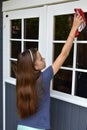 Girl cleaning the windows of the summer  house Royalty Free Stock Photo