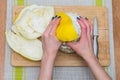 Girl cleans a pomelo on a wooden board Royalty Free Stock Photo