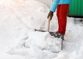 Girl cleans snow shovel on the site near his house. sunlight Royalty Free Stock Photo