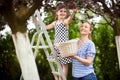 Girl climbed on the ladder picking cherries with her mom