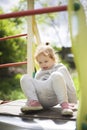 The little girl climbed onto a children slide on a playground for children and is very happy to play Royalty Free Stock Photo