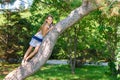 Girl climbed a tree playing in a city park