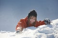 Girl climber climbs a snow cornice using ice axes through snow blown away by the strong wind. Royalty Free Stock Photo