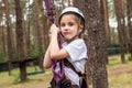 Girl climber hanging on insurance in the forest