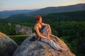 Girl climber on mountain peak on high altitude in evening Royalty Free Stock Photo