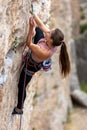 girl climber snaps a rope into a quickdraw. rock climber on a difficult route Royalty Free Stock Photo