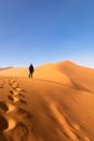 Girl climbing Big Daddy Dune, Sossusvlei, Namib-Naukluft National Park, Namibia.