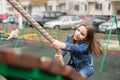 Girl climbing the hill on a rope.