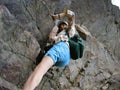 Girl climbing rocks, striving to the peak of the mountain Royalty Free Stock Photo