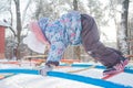 Girl climbing on winter monkey bar on snowy playground