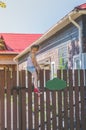 Girl climbs the fence on a summer day Royalty Free Stock Photo