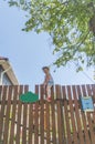 Girl climbs the fence on a summer day Royalty Free Stock Photo