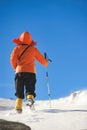 Girl climbs the mountain through snow blown away by the strong wind.