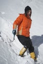 Girl climbs the mountain through snow blown away by the strong wind.