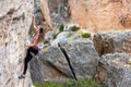 The girl climbs the rock. The climber is training to climb the rock. A strong athlete overcomes a difficult climbing route. Royalty Free Stock Photo