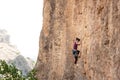 The girl climbs the rock. The climber is training to climb the rock. A strong athlete overcomes a difficult climbing route. Royalty Free Stock Photo