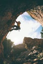 The girl climbs the rock in the shape of an arch, A man is belaying a climbing partner Royalty Free Stock Photo