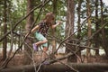 Girl climbs a tree in a forest