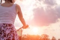 Girl close up with bike at the summer sunset on the road in the city park. Cycling down the street to work at summer sunset. Royalty Free Stock Photo