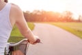 Girl close up with bike at the summer sunset on the road in the city park. Cycling down the street to work at summer sunset. Royalty Free Stock Photo