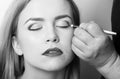 Girl with closed eyes getting makeup on eyelids Royalty Free Stock Photo