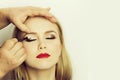 Girl with closed eyes and red lips getting makeup Royalty Free Stock Photo