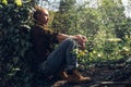 Girl with closed eyes resting, leaning against tree. Tourism Hiking Survival Bushcraft Concept