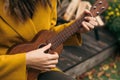 Girl closeup playing an acoustic instrument ukulele in autumn on the terrace