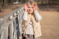 Girl closing face with her hands and happy plays outdoor