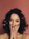 Girl closing mouth with her hands and looking at camera Royalty Free Stock Photo