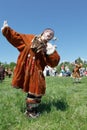 Girl in clothing aborigine of Kamchatka dancing on the green grass. Kamchatka, Russia