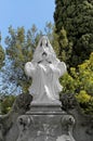 Girl on cloud praying piously over the grave of a dead person as a sign of remembrance and respect for the deceased