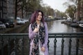Girl in the coat enjoying city. Young woman looking to the side on Amsterdam channel, Netherlands