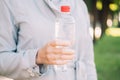 Girl in a coat holds a plastic bottle with mineral water Royalty Free Stock Photo