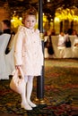 Girl in coat stands near to lamp post