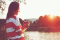 Girl with coffee at river sunrise Royalty Free Stock Photo