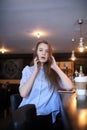 Girl with coffee. Young beautiful girl is sitting in a cafe and Royalty Free Stock Photo