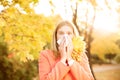 Girl with cold rhinitis on autumn background. Fall flu season. I Royalty Free Stock Photo