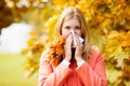 Girl with cold rhinitis on autumn background. Fall flu season. I