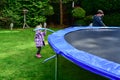 The girl collects a new trampoline and pulls the springs to jump Royalty Free Stock Photo