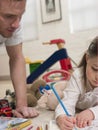 Girl Coloring Picture While Father Looking At It